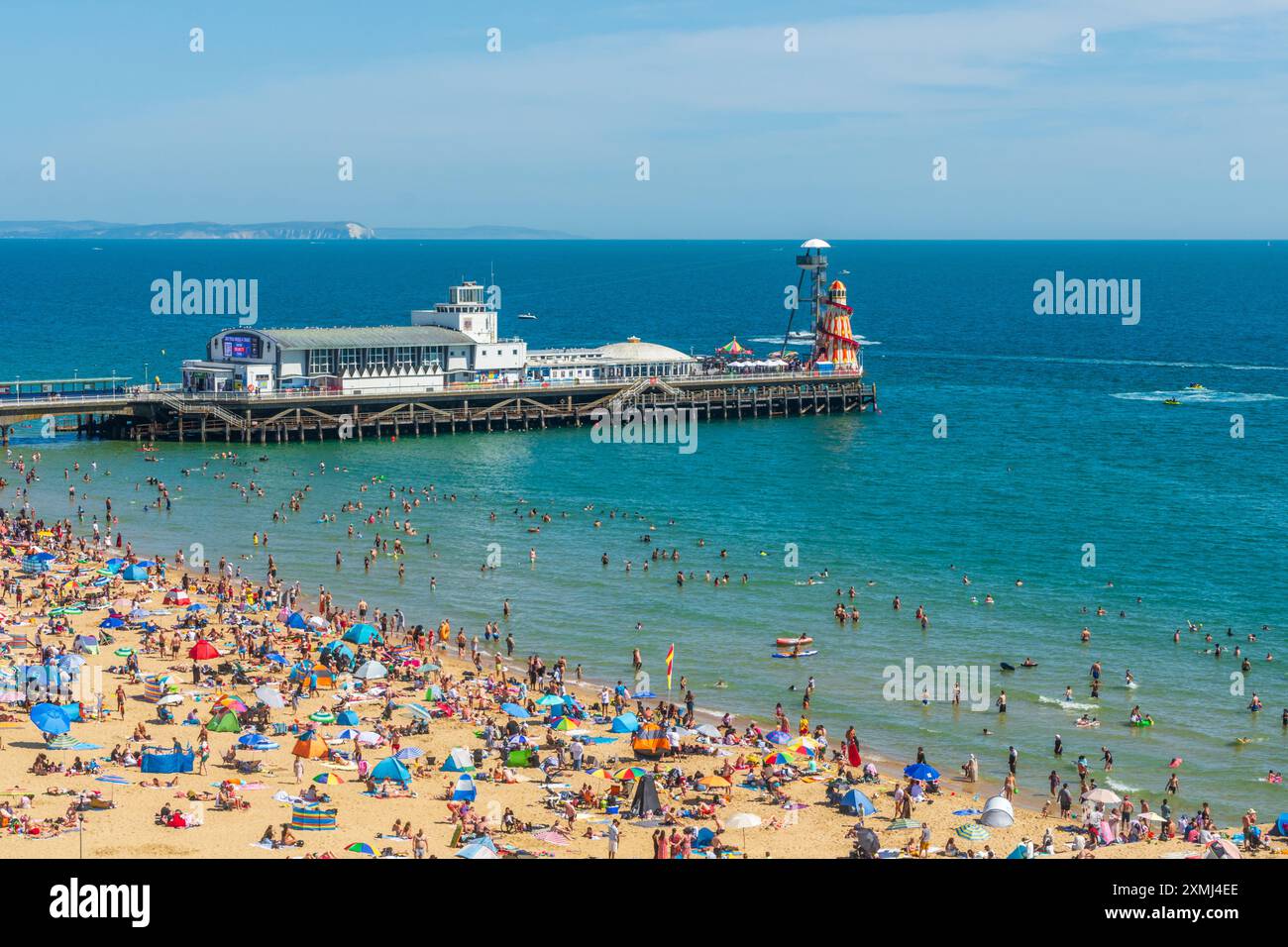 West Cliff Beach, Bournemouth, Großbritannien - 28. Juli 2024: Blick von der Klippe des Bournemouth Pier und den überfüllten Strand von Menschen, die das heiße Wetter genießen. Stockfoto