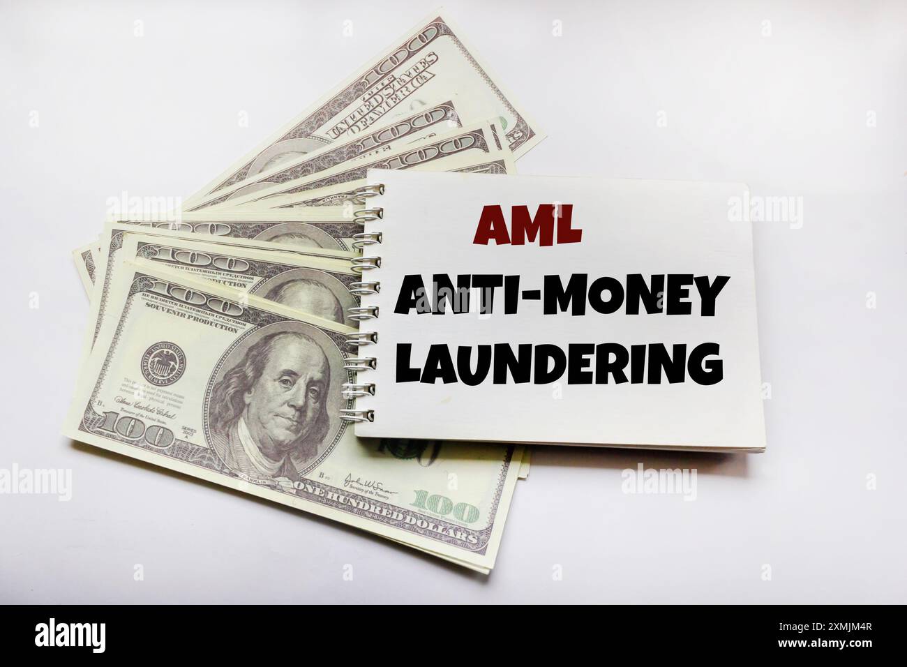 Geschäftskonzept. Auf dem Notizblock befindet sich neben den Dollars die Aufschrift Anti-Money Laundering. Stockfoto