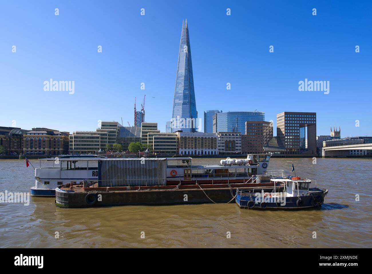 Der Shard Wolkenkratzer von der Themse aus mit Booten, die an einem sonnigen Tag vor Anker liegen. London - 28. Juli 2024 Stockfoto