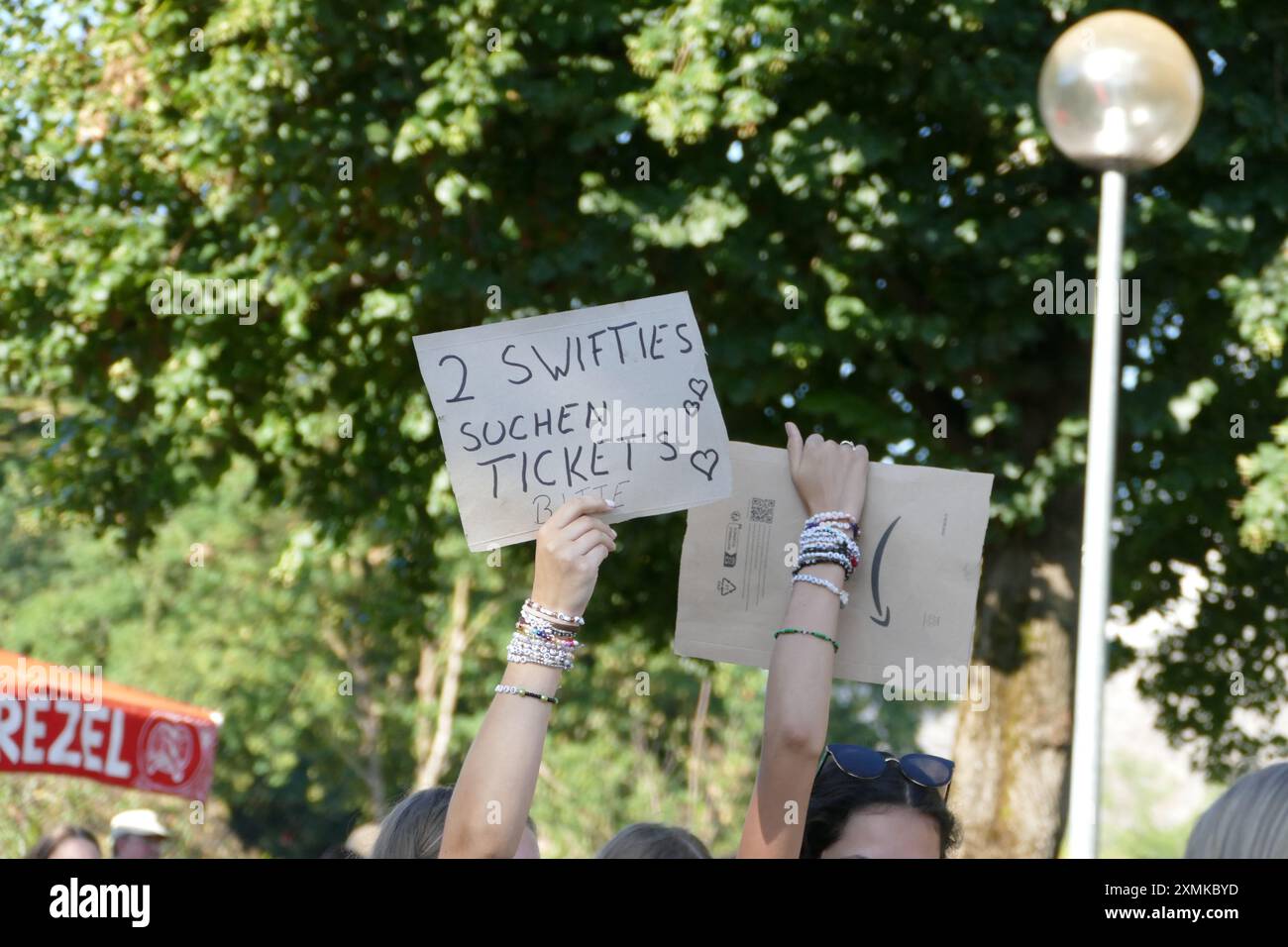 Taylor Swift Konzert im Münchner Olympiapark, Tickets ausverkauft, Sommer 2024. Zwei Mädchen, die bettelten, mit Text an Bord '2 Swifties suchen nach Tickets'.tic Stockfoto