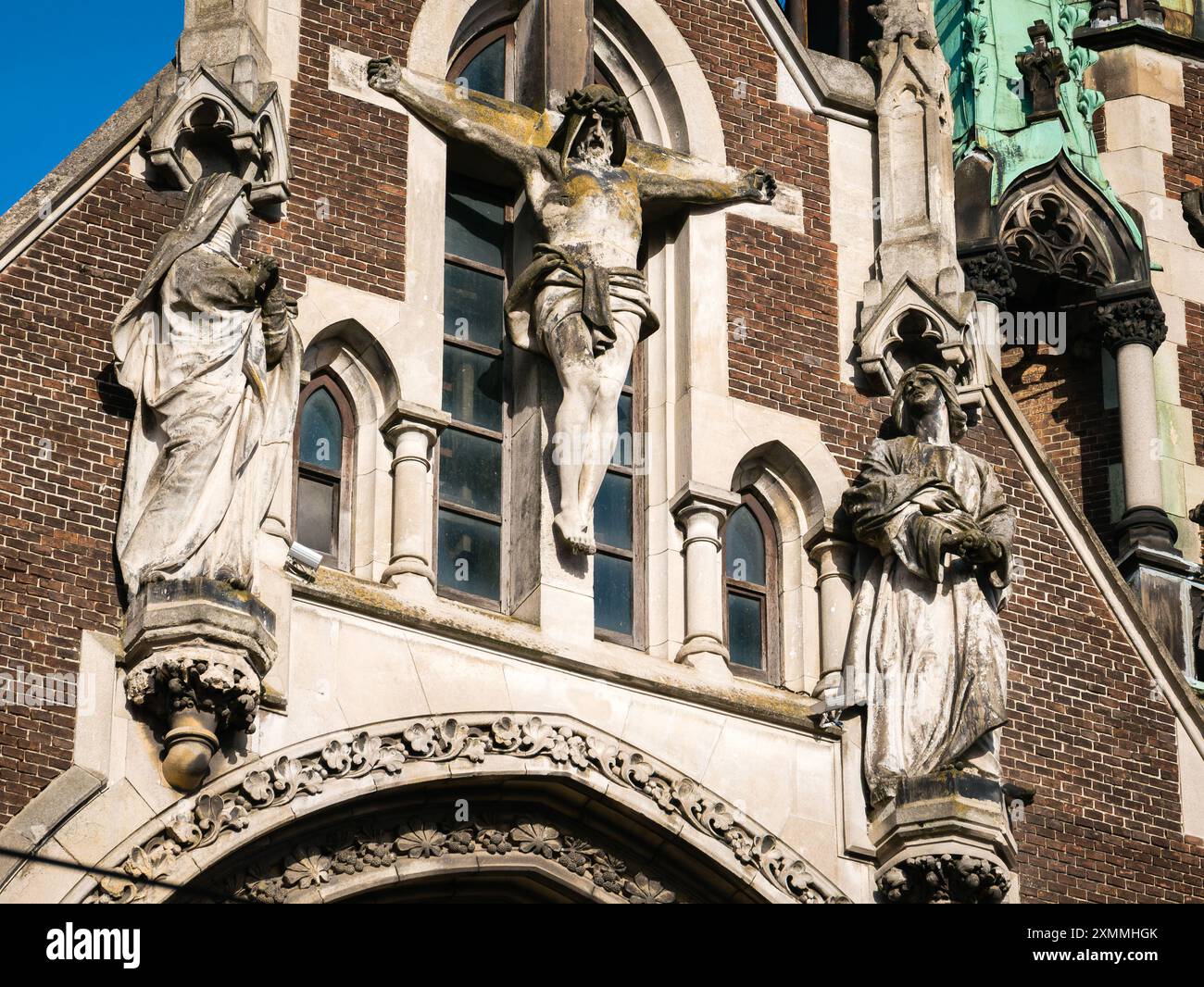 Skulpturengruppe „Kreuzigung mit Gehilfen“ (Bildhauer Petro Voytovych 1911) an der Fassade der Kirche der Heiligen Olga und Elisabeth Stockfoto