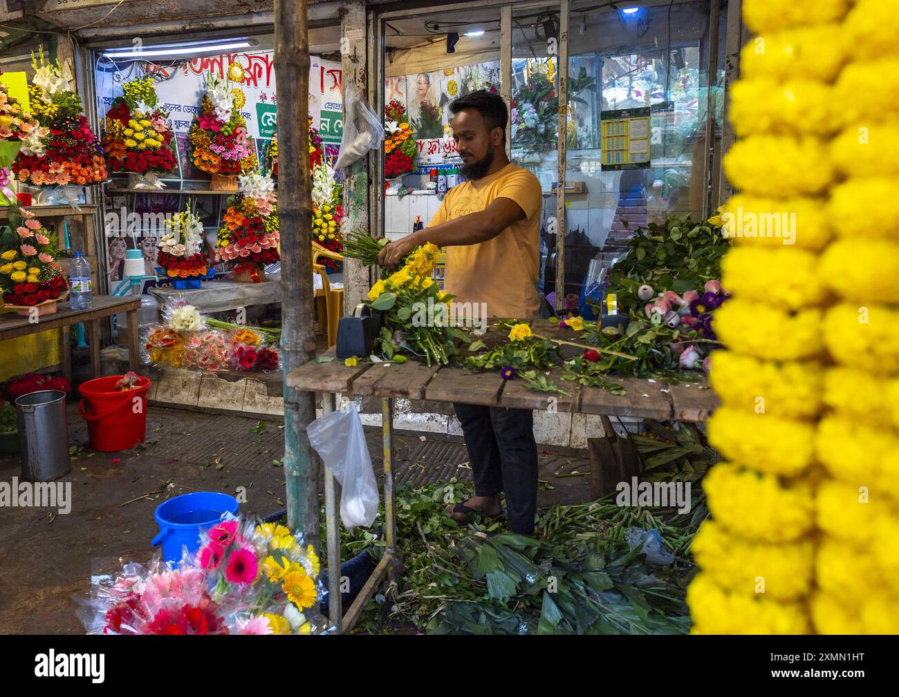 Bangladeschi Mann verkauft Blumen auf dem Blumenmarkt, Dhaka Division, Dhaka, Bangladesch Stockfoto