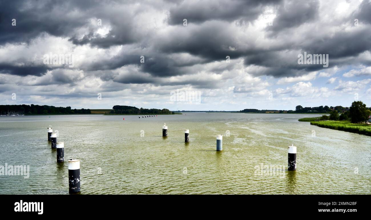 Schifffahrtskanal in der Ostsee im Peenestrom bei Usedom unter dunklem bewölktem Himmel Stockfoto