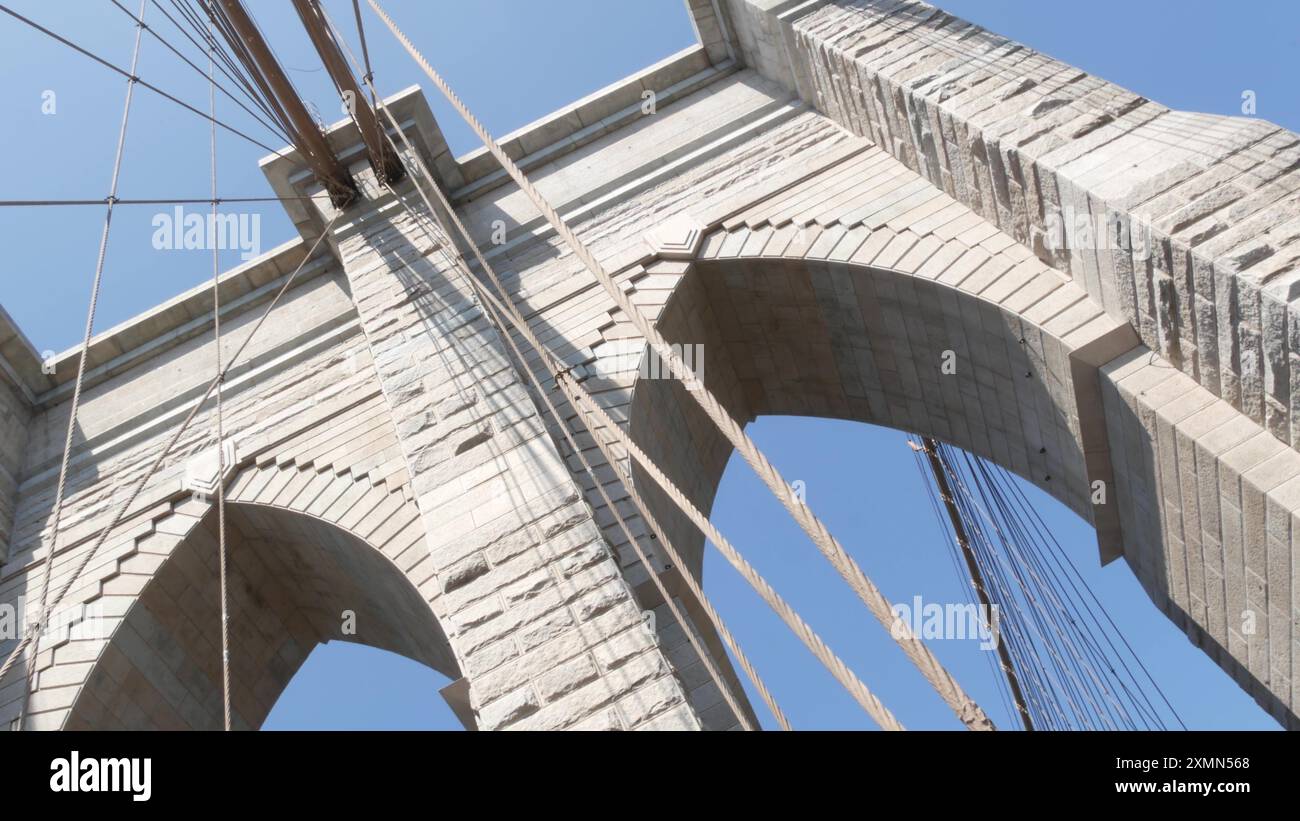 Brooklyn Bridge nach Manhattan, Kabel und blauer Himmel. Symbol New York City, Reiseziel USA. Architektur der Vereinigten Staaten von Amerika, touristisches Wahrzeichen. Kabelbrücke. Niederländischer Winkel. Stockfoto