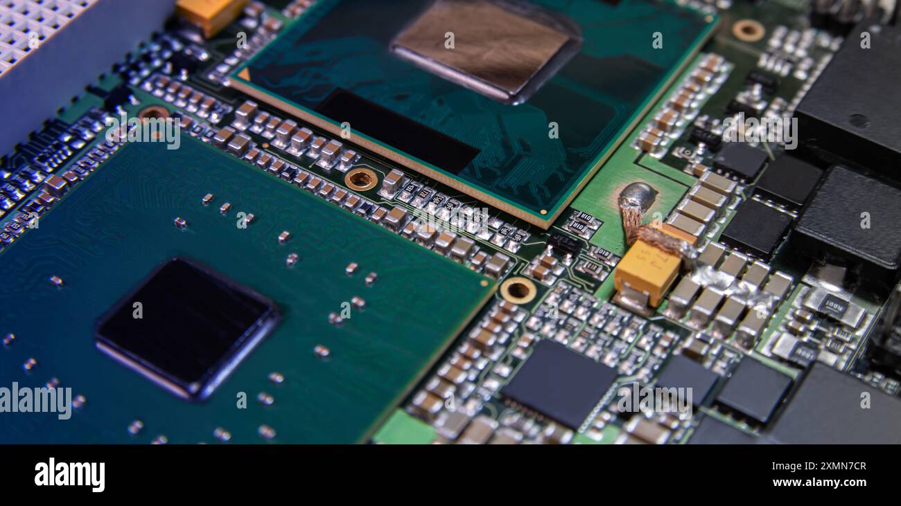 Detaillierte Nahaufnahme einer elektronischen Leiterplatte mit Mikrochips, Widerständen und anderen Komponenten, die moderne Technologie und Hardware repräsentieren. Stockfoto