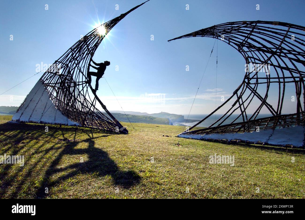 Bild von Roger Bamber: 14. August 2005: Der Künstler Simon Pascoe von Red Earth stellt die greenwood-, Flecht- und Daub-Installation „Vanishing Point“ am Rand der zerbröckelnden Kreidefelsen von Birling Gap, Seven Sisters, East Sussex. Die Skulptur, die in Zusammenarbeit mit dem National Trust geschaffen und vom Arts Council finanziert wurde, war umstritten. Es hat einige Einheimische und Spaziergänger wegen seines Eindringens in einen berühmten Schönheitsort beleidigt. Aber ihre Schöpfer und viele Unterstützer sagen, dass die temporäre Skulptur die kontinuierliche Erosion der Landschaft markiert und das Bewusstsein für den Wandel erhöht Stockfoto