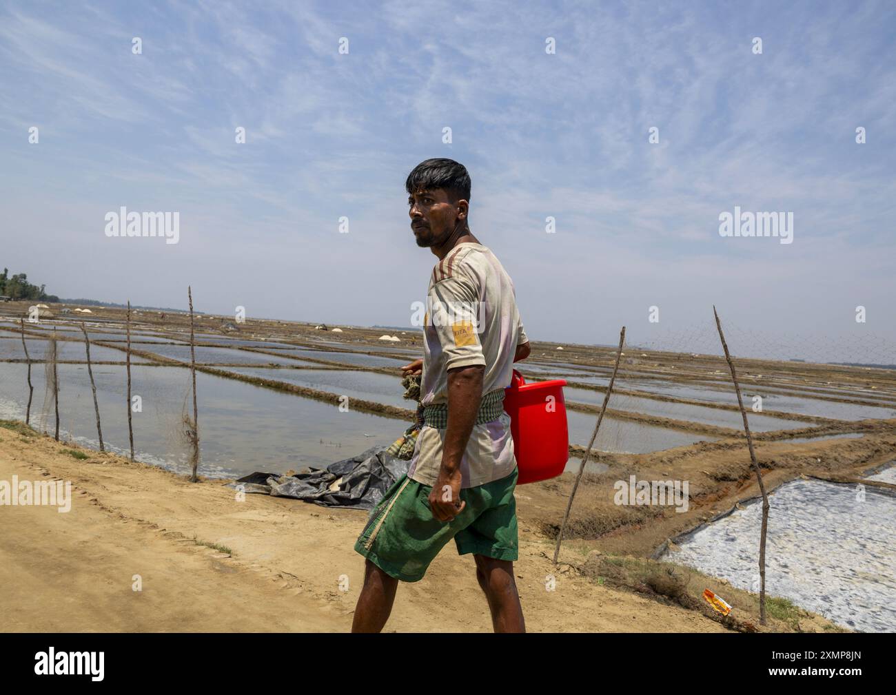 Bangladeschi Mann arbeitet in einem Salzfeld, Chittagong Division, Maheshkhali, Bangladesch Stockfoto