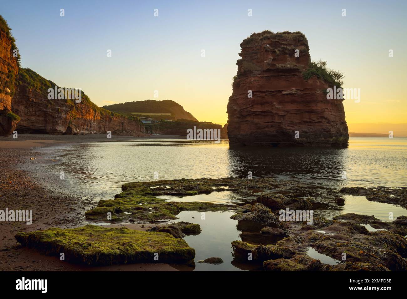 Ein Sandstein in der Ladram Bay nahe Sidmouth im Südosten von Devon, der bei Sonnenaufgang im Juli gefangen wurde. Stockfoto