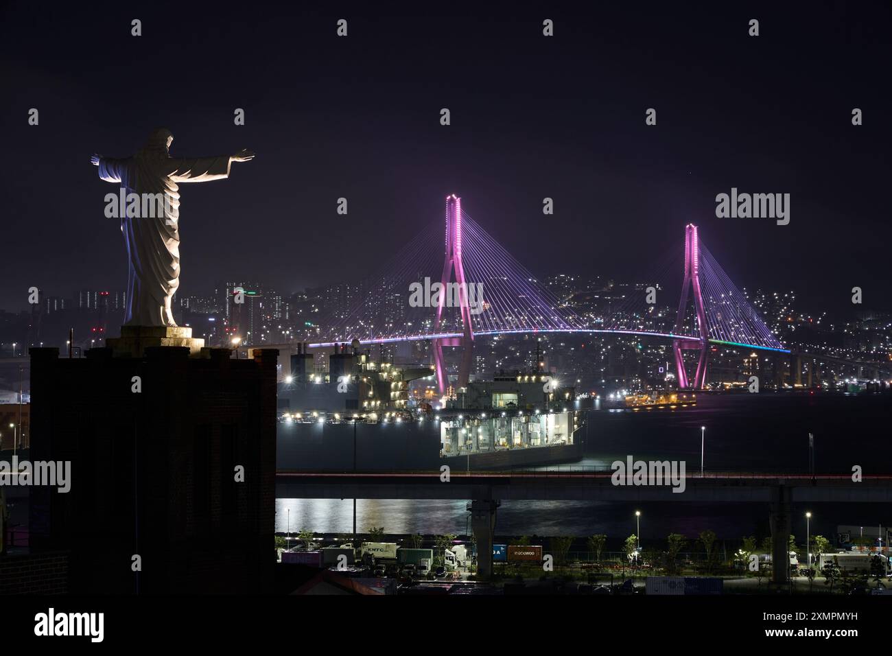 Nächtlicher Blick auf die Busan Port Bridge mit der riesigen Jesus Statue in Basan, Soth Korea Stockfoto