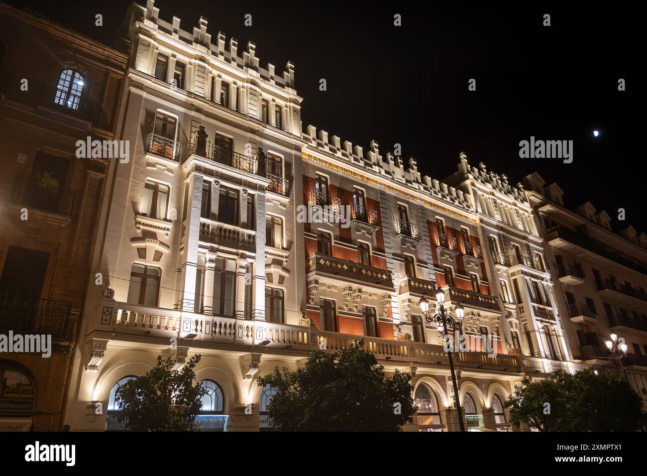 Seguros Santa Lucia Gebäude beleuchtet bei Nacht in Sevilla, Spanien. Hauptsitz der Versicherungsgesellschaft von 1910 an der Constitution Avenue, designe Stockfoto