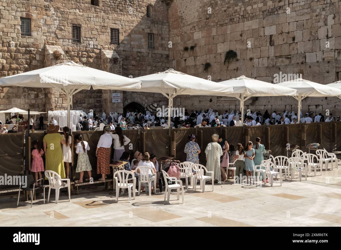 Weibliche jüdische Anbeter Klammern den Zaun, um auf die Männerseite der Westmauer zu schauen. Die Westmauer, auch bekannt als Klagemauer im Westen und Al-Buraq-Mauer im Islam, ist ein Pilgerziel für jüdische Gläubige. Es befindet sich in der Altstadt von Jerusalem und ist ein Teil der Stützmauer des Tempelbergs. Eine Metallwand teilte das Gebiet in zwei Teile auf: Männer auf der linken und Frauen auf der rechten Seite. Den ganzen Tag über besuchen jüdische Gläubige die Stätte, um zu beten, die heiligen Bücher der Thora zu lesen und Papiernotizen in den Rissen der Mauer zu hinterlassen. Das ganze Gebiet wird von israelischen Soldaten überwacht. Stockfoto