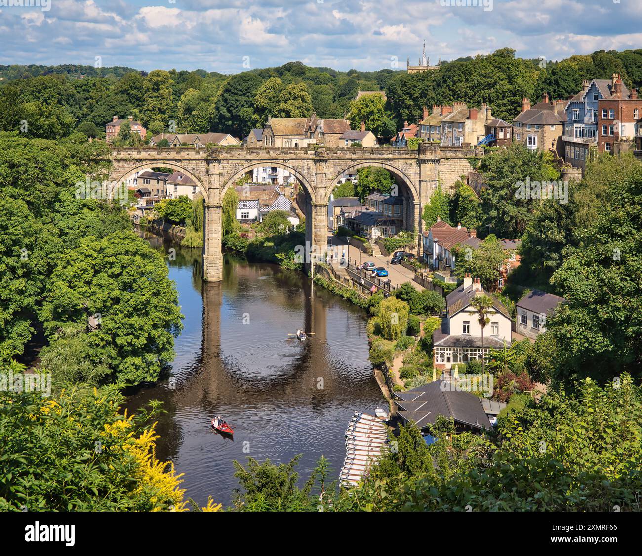 Sommer im Herzen von Knaresborough mit Menschen am Fluss und auf dem Wasser in den hellen, fröhlichen Ruderbooten. Stockfoto