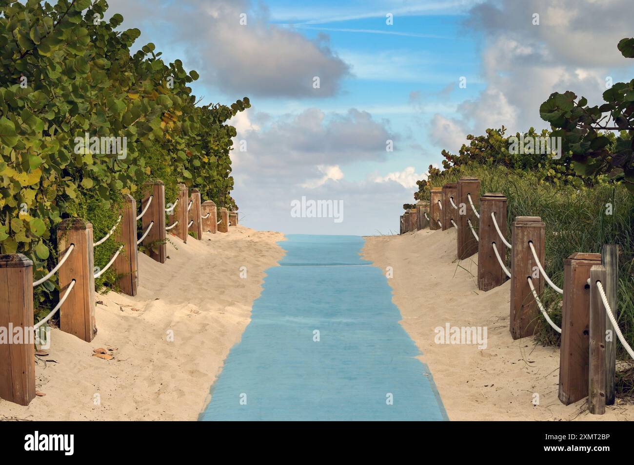 Fußweg zu einem Strand mit Sand und Seilen Holzzäunen auf beiden Seiten. Keine Personen. Urlaubskonzept. Stockfoto