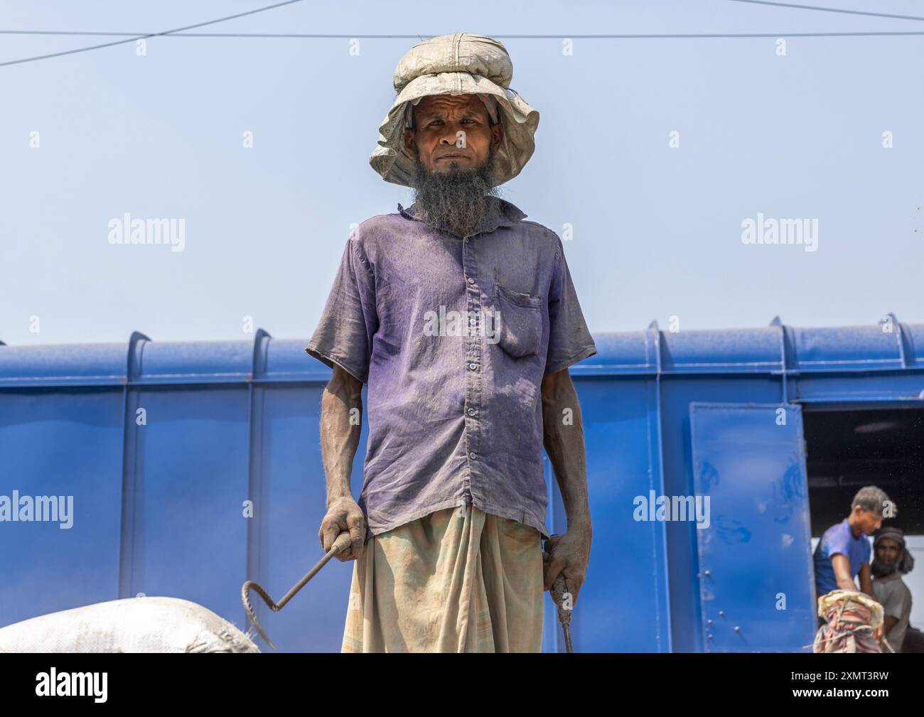 Bangladeschische Arbeiter entladen Zementsäcke aus einem Zug, Khulna Division, Abhaynagar, Bangladesch Stockfoto