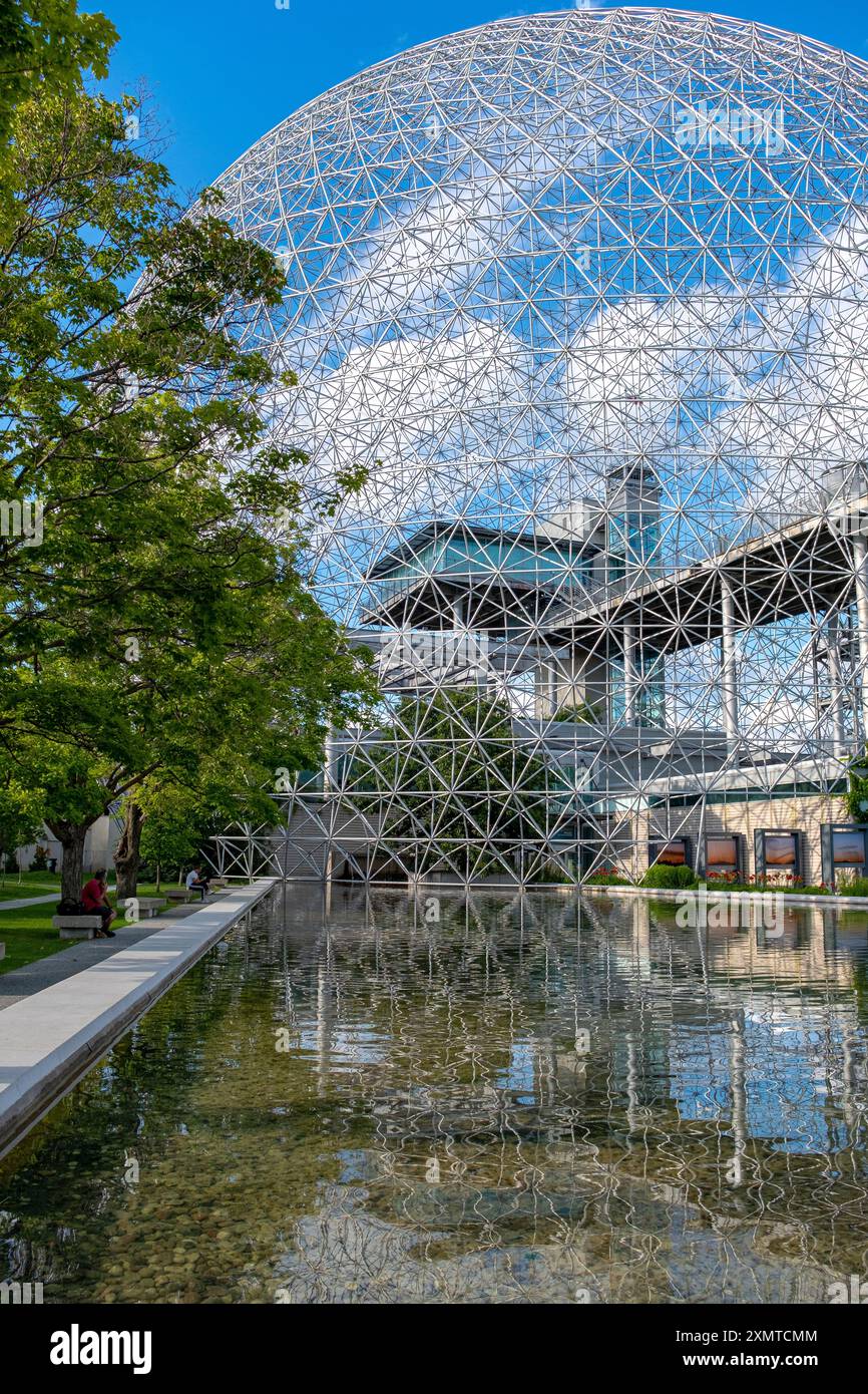 Montreal, Kanada - 23. Juli 2023: Vertikales Foto der Expo '67 Biosphäre mit einigen nicht erkennbaren Menschen im Vordergrund. In einem sonnigen Sommer Stockfoto