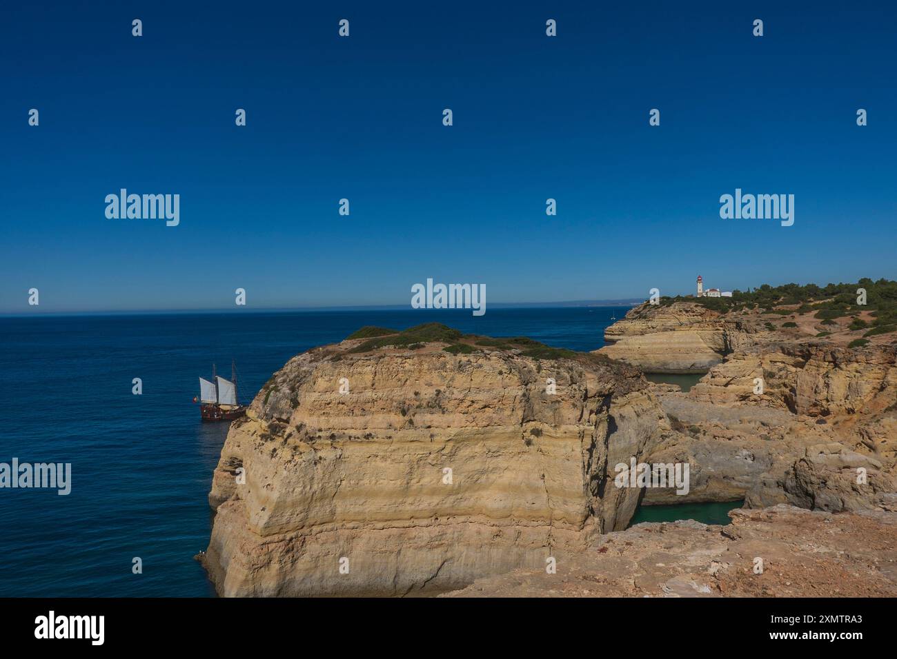 Küste, Höhlen von Benegil und Boot vom Seven Hanging Valleys Trail aus gesehen, Gemeinde Lagoa, Algarve, Portugal. Stockfoto