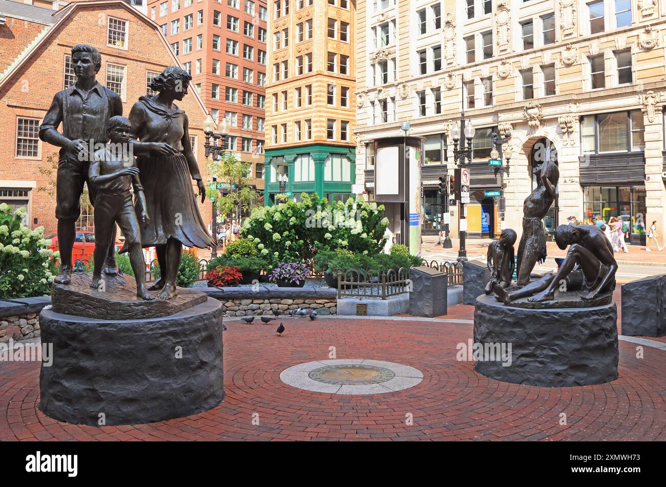 Blick aus dem Boston Irish Famine Memorial Park mit der Statue einer armen Familie, die während des Großen Hungers hungerte Stockfoto
