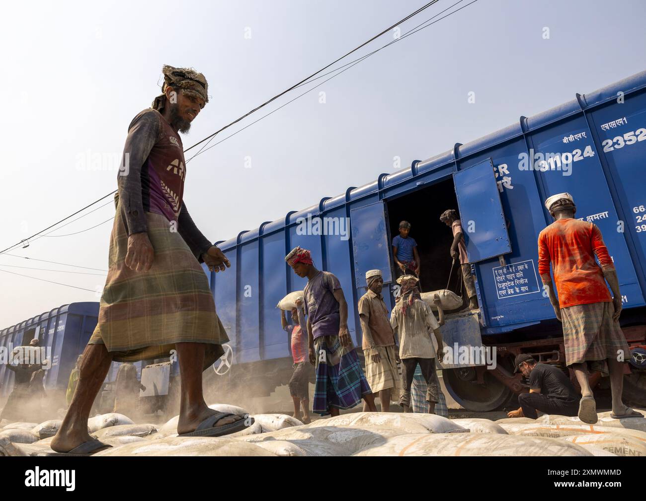 Bangladeschische Arbeiter entladen Zementsäcke aus einem Zug, Khulna Division, Abhaynagar, Bangladesch Stockfoto