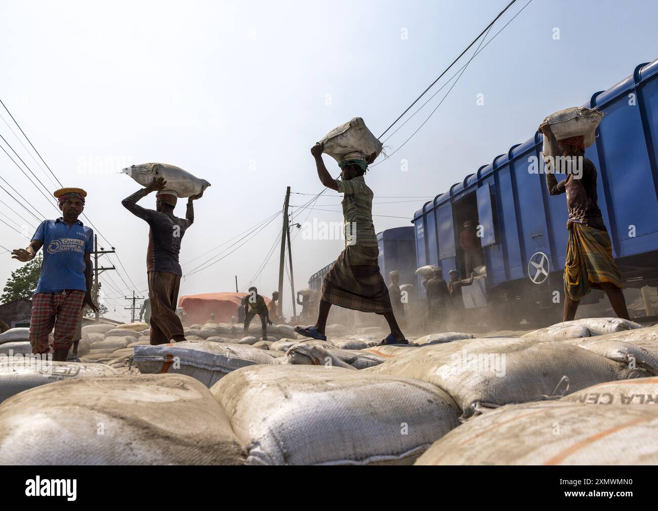 Bangladeschische Arbeiter entladen Zementsäcke aus einem Zug, Khulna Division, Abhaynagar, Bangladesch Stockfoto