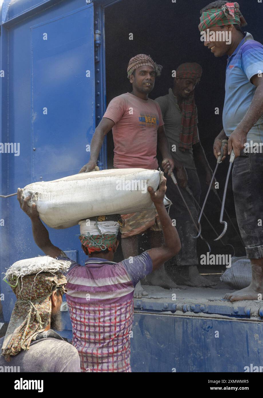 Bangladeschische Arbeiter entladen Zementsäcke aus einem Zug, Khulna Division, Abhaynagar, Bangladesch Stockfoto