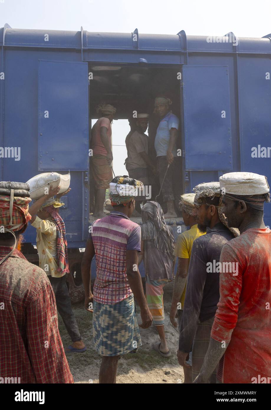Bangladeschische Arbeiter entladen Zementsäcke aus einem Zug, Khulna Division, Abhaynagar, Bangladesch Stockfoto