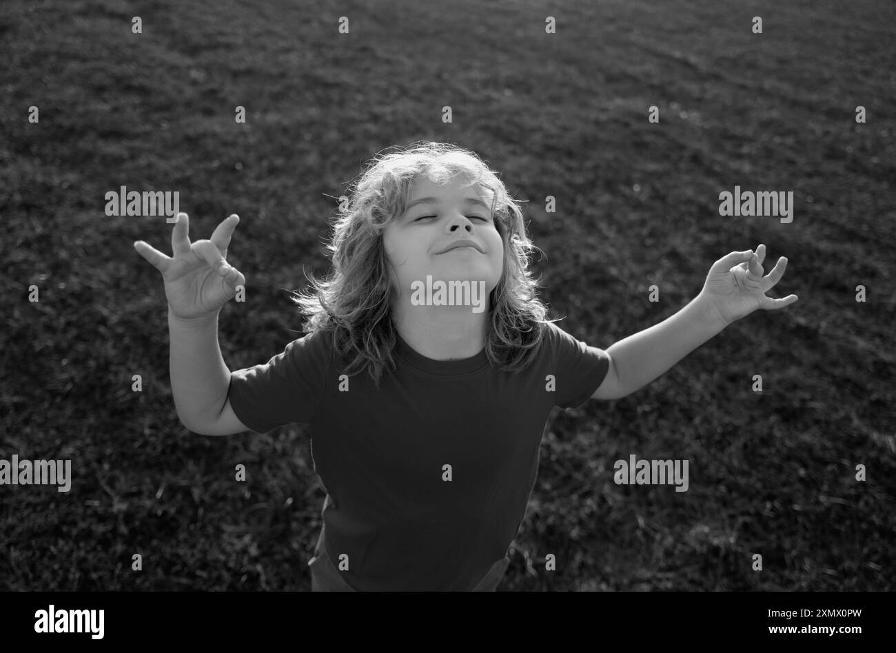 Kind, das frische Luft atmet. Kinder Ruhe und Entspannung in der Natur. Das kleine Kind meditiert während des Yoga. Freiheit und unbeschwertes Konzept. Im Freien Stockfoto