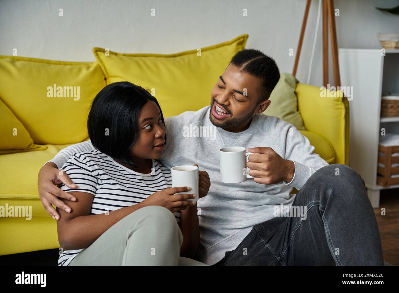 Afroamerikanisches Paar genießt gemütliche Momente mit Kaffee und Unterhaltung. Stockfoto