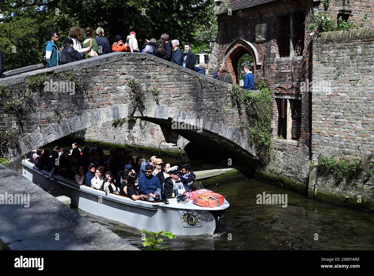 Ein Kanalboot, das unter der Bonifacius-Brücke in Brügge, Belgien, vorbeifährt. Stockfoto