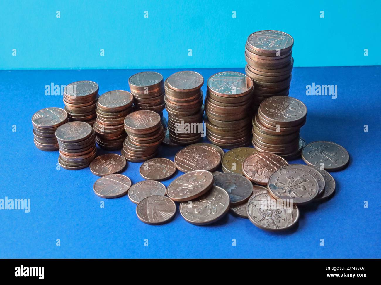 Britische Low-Vale-Münzen auf blauem Hintergrund mit 1p-, 2p-Münzen im Lieferumfang enthalten. Seit vielen Jahren gibt es Spekulationen darüber, wann sie eingestellt werden könnten Stockfoto