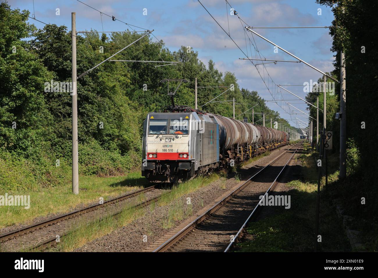 Eisenbahnverkehr auf der Bahnstrecke Oberhausen Arnhem NL - Hollandstrecke Güterzug der belgischen LINEAS, bespannt mit einer Bombardier TRAXX E-Lok. Kesselwagen. Durchfahrt der Bahnhof/Haltepunkt Elten Emmerich am Rhein, Nordrhein-Westfalen, DEU, Deutschland, 19.06.2024 *** Bahnverkehr auf der Eisenbahnlinie Oberhausen Arnhem NL Holland-Linie Güterzug der belgischen LINEAS, geführt von einer Bombardier TRAXX E-Lokomotive Tankwagen Passage von den Bahnhof Haltestelle Elten Emmerich am Rhein, Nordrhein-Westfalen, DEU, Deutschland, 19 06 2024 Stockfoto