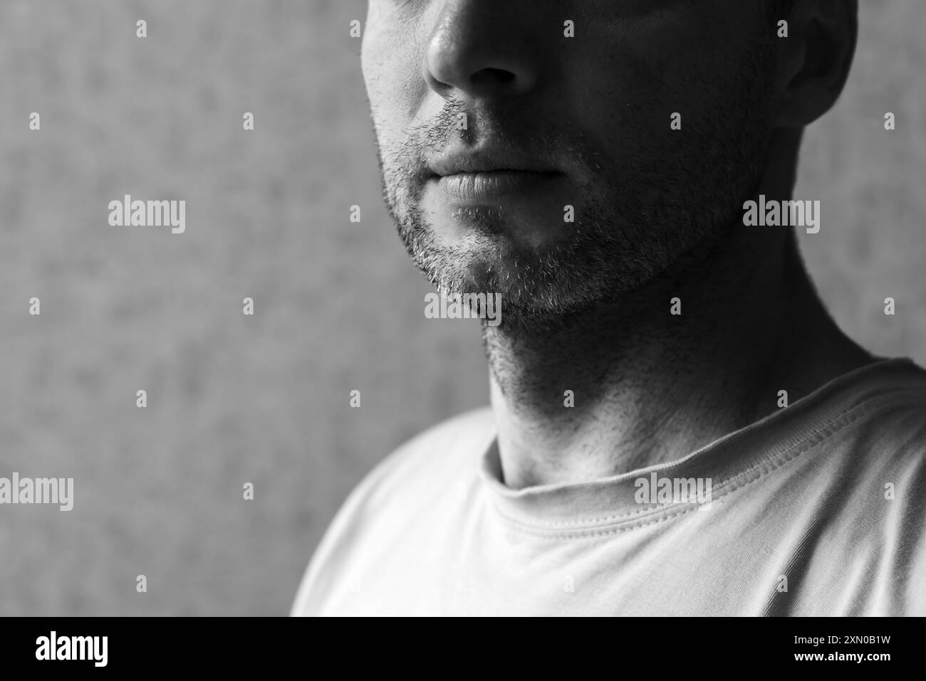 Unrasiertes Kinn eines europäischen Mannes, Nahaufnahme eines Schwarzweißfotos Stockfoto