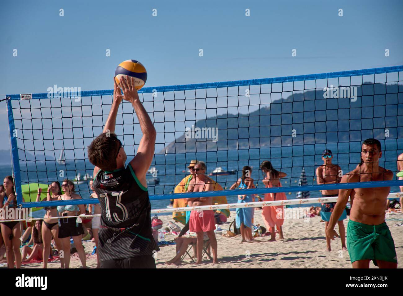 Während des 3x3 Ladeira Beach Volleyball Turniers in Baiona springen die Spieler mit erhobenen Armen und führen einen mächtigen Block in die ne aus Stockfoto
