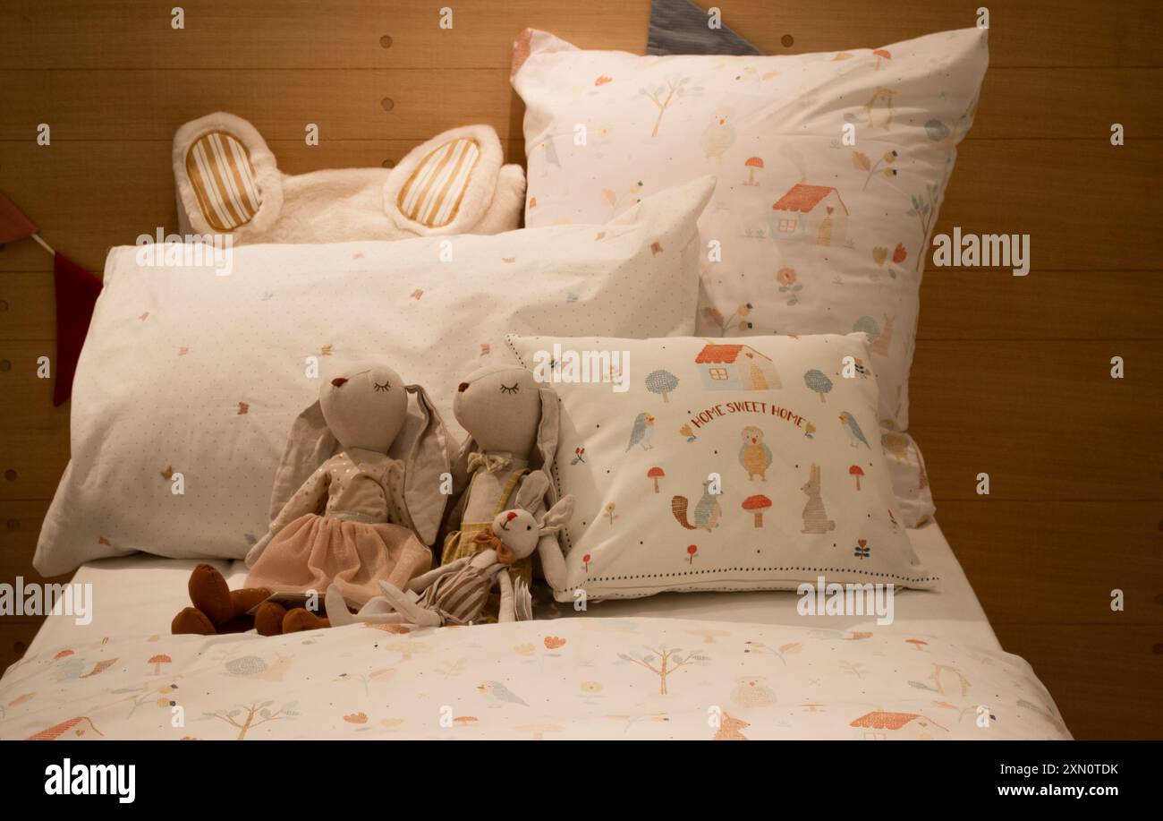 Moskau, Russland, November 2020: Nahaufnahme eines Bettes mit Zara Babybettwäsche, Kissen und einer Familie von Spielzeugkaninchen. Stockfoto