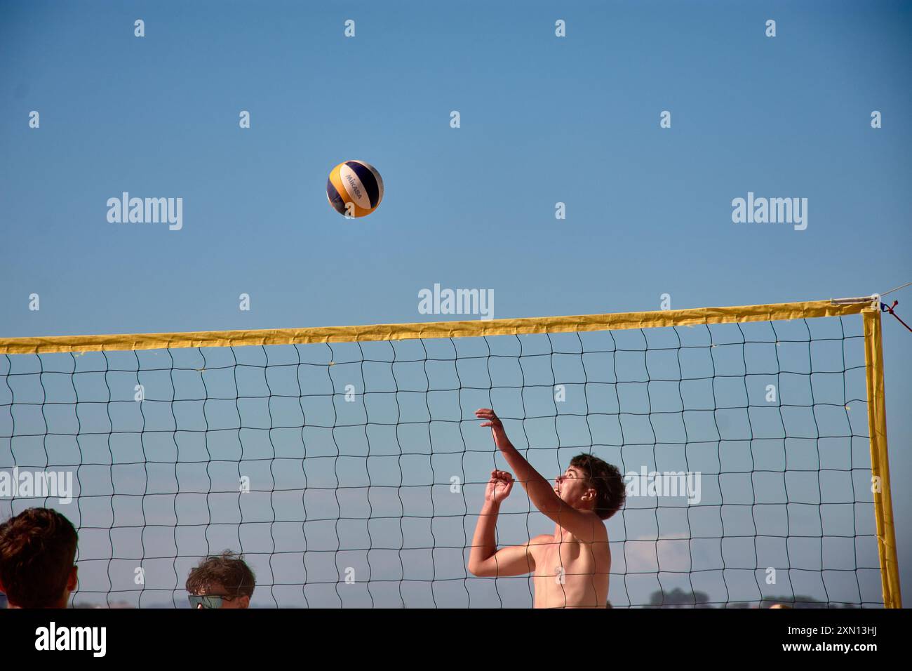 Während des 3x3 Ladeira Beach Volleyball Turniers in Baiona springen die Spieler mit erhobenen Armen und führen einen mächtigen Block in die ne aus Stockfoto