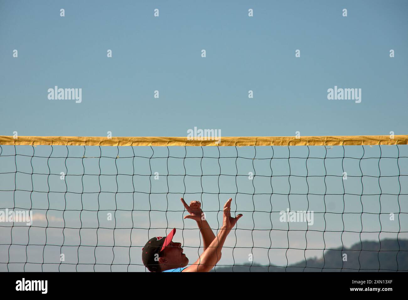 Während des 3x3 Ladeira Beach Volleyball Turniers in Baiona springen die Spieler mit erhobenen Armen und führen einen mächtigen Block in die ne aus Stockfoto