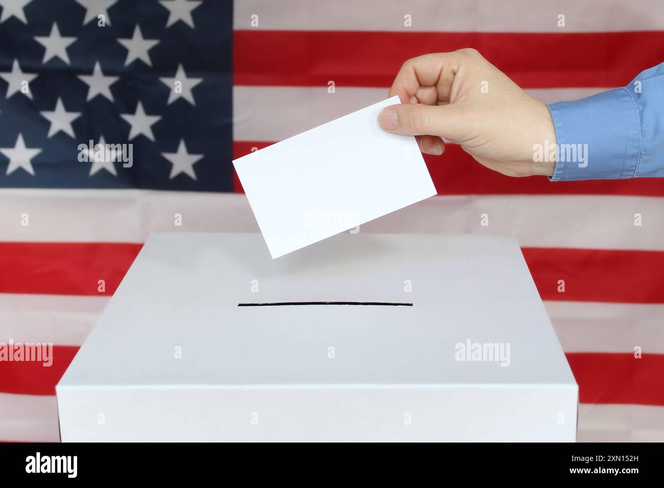 Nahaufnahme einer männlichen Hand, die Stimme in einer Wahlurne mit US-Flagge abgibt Stockfoto