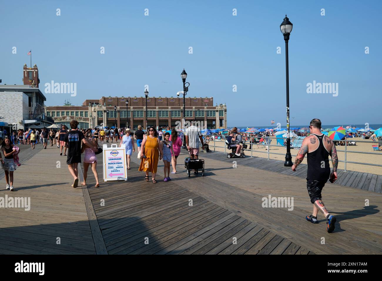 An einem sonnigen Tag laufen Menschenmassen auf dem Boardwalk im Asbury Park in der Nähe der Convention Hall Stockfoto