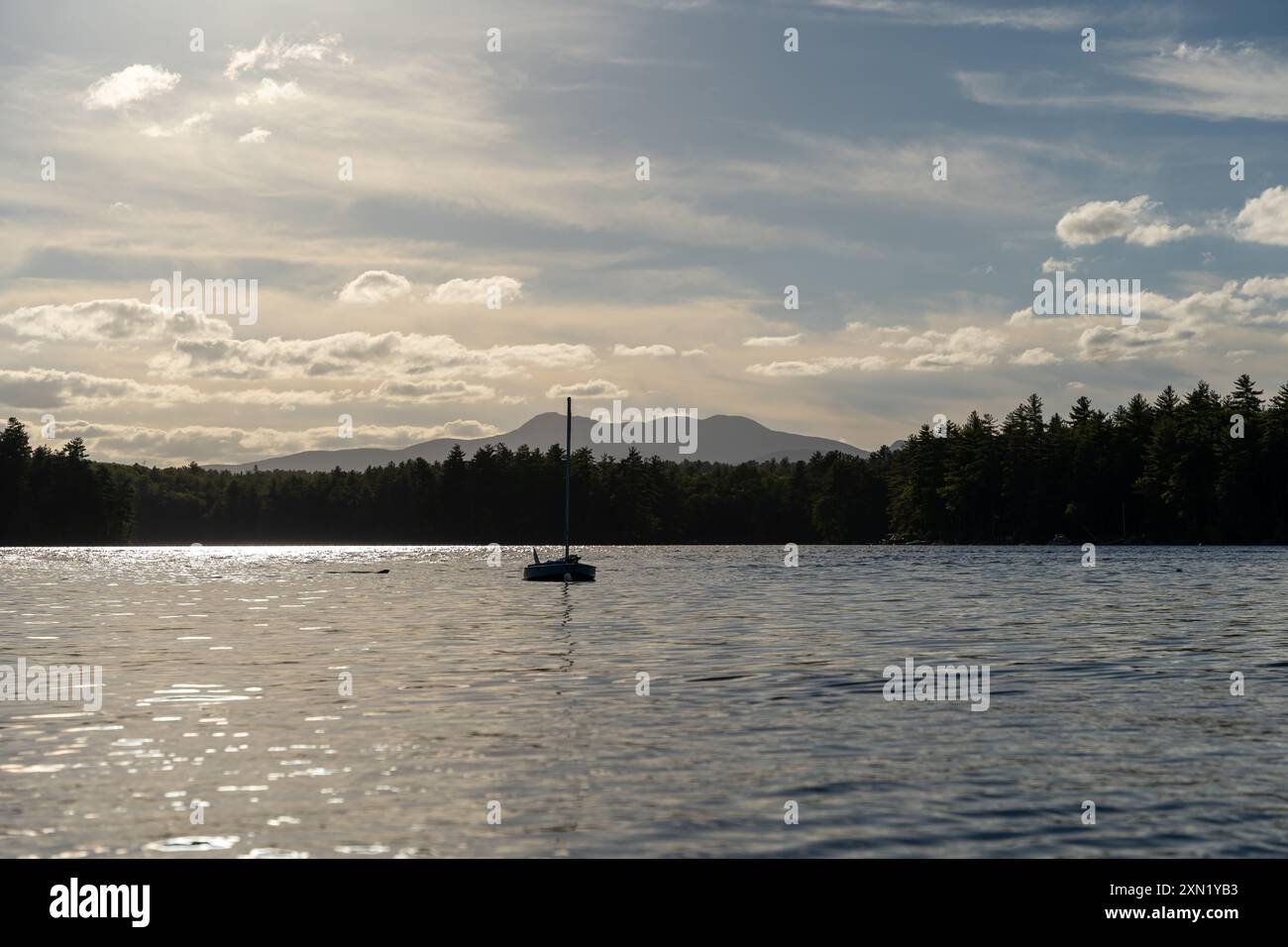 Ein herrlicher Blick auf ein Segelboot auf dem Lake Conway in New Hampshire bei Sonnenuntergang. Stockfoto