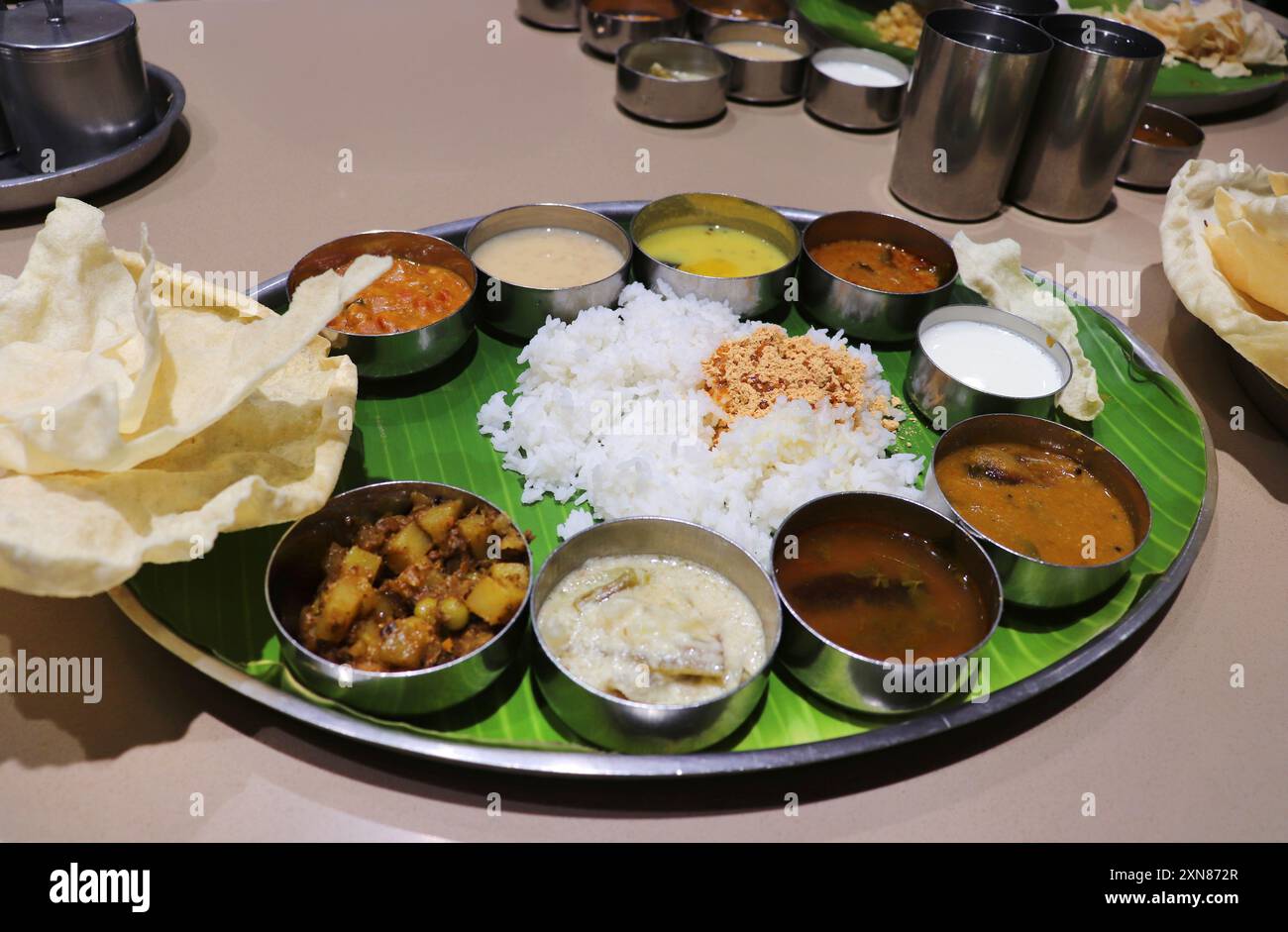Ein südindischer Thali oder eine Mahlzeit besteht aus gedämpftem Reis, Sambar, Rasam, Gemüsecurrys, Avial, Kokos-Chutney, Gurken, Papadum, Quark oder Joghurt Stockfoto Ein südindischer Thali oder eine Mahlzeit besteht aus gedämpftem Reis, Sambar, Rasam, Gemüsecurrys, Avial, Kokos-Chutney, Gurken, Papadum, Quark oder Joghurt Stockfoto