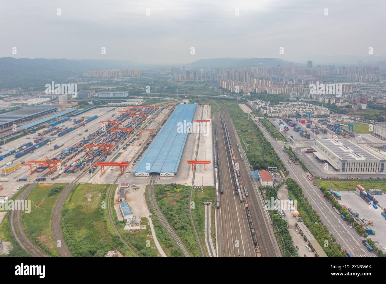 (240731) -- CHONGQING, 31. Juli 2024 (Xinhua) -- ein Luftdrohnenfoto vom 30. Juli 2024 zeigt die Tuanjiecun-Station, die Xinglongchang-Station und den Trockenhafen des New International Land-Sea Trade Corridor (L-R) im Chongqing International Logistics Hub Park im Shapingba-Bezirk in Chongqing, Südwest-China. Der Chongqing International Logistics Hub Park ist zusammen mit seinen 62 Güterzugstrecken zu einem wichtigen Drehkreuz internationaler Güterzüge in der westlichen Region des Landes geworden. Da viele internationale Logistikkanäle in Chongqing zusammenlaufen, nutzt die bergige Stadt ihre Stockfoto