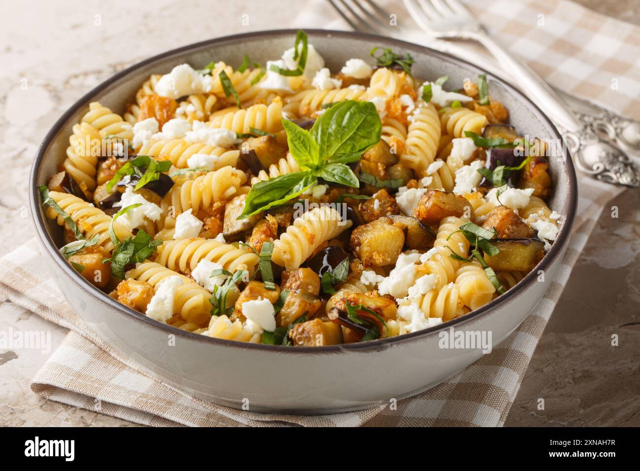 Traditionelles Nudelgericht mit sautiertem Auberginen-Knoblauch und Feta-Closeup auf der Schüssel auf dem Tisch. Horizontal Stockfoto