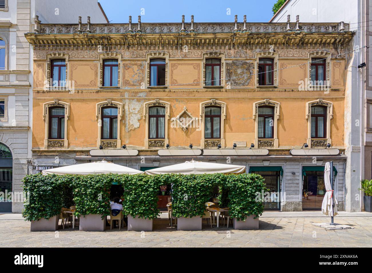 Restaurant Al Conte Ugolino da Marino Terrasse vor der verblassten Fassade des Hotels Nuovo Milano an der Piazza Cesare Beccaria, Mailand, Italien Stockfoto