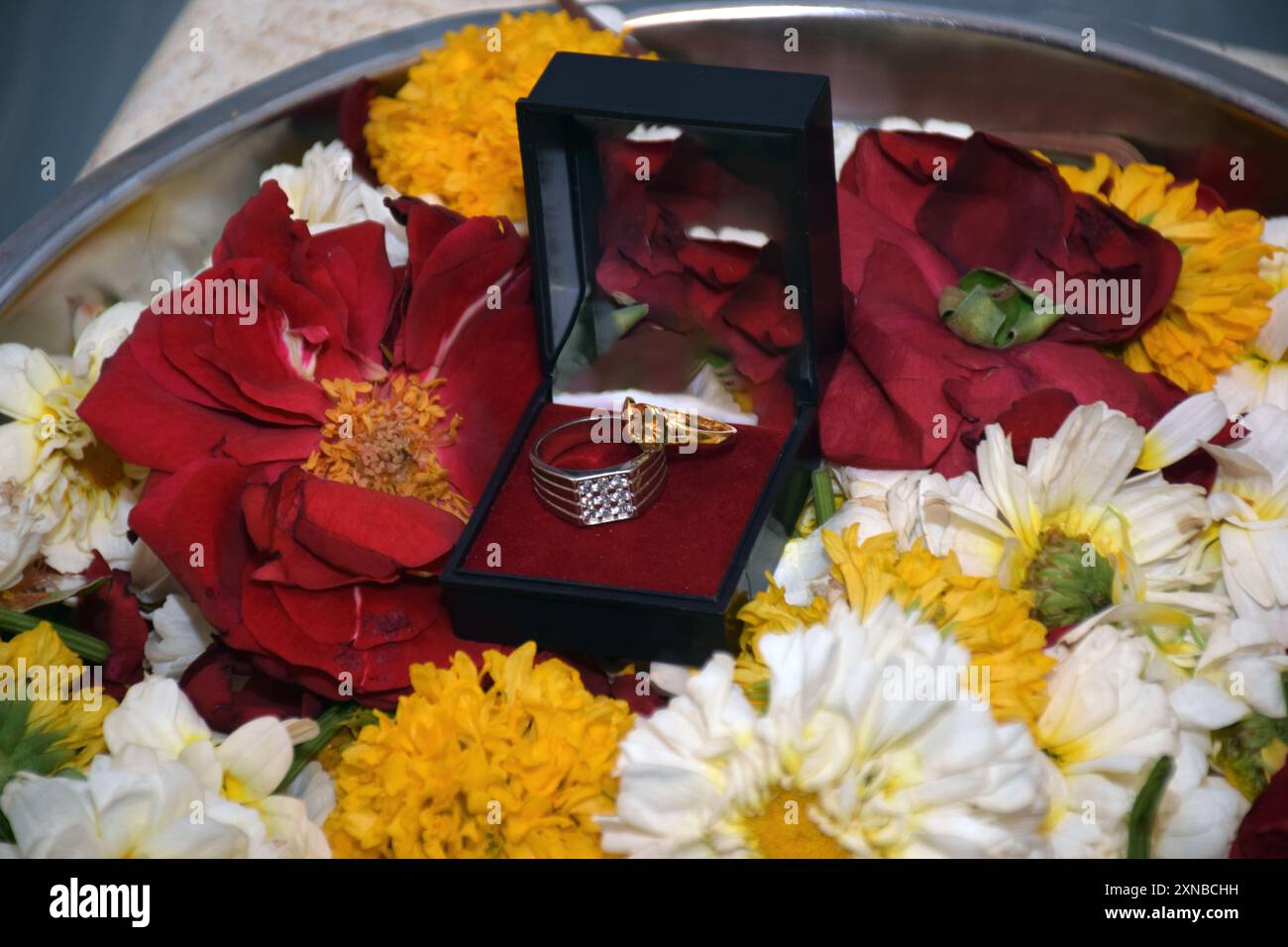 Ringzeremonie, schöner Verlobungsring auf Blumenhintergrund Unschärfe selektiven Fokus auf Thema Stockfoto