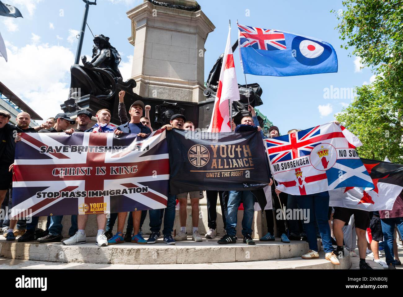 Youth Alliance, Unterstützer von Tommy Robinson, die sich zu einem protestmarsch zum Trafalgar Square gegen Einwanderung versammeln. Religiöse Fahnen Stockfoto