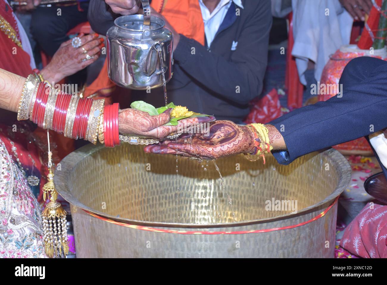 Hochzeitspaar schöne Hände, hinduistische Bräutigam und Braut Hände während der Hochzeitszeremonie, Wasserfinsternis Zeremonie Stockfoto