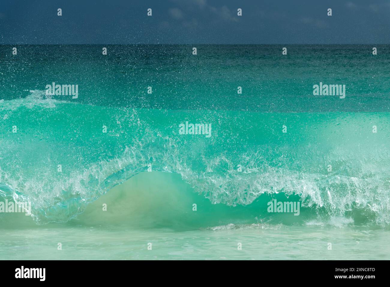 Mächtige riesige Welle, die am Ufer der Seychellen bricht, Ozean abstrakt Stockfoto