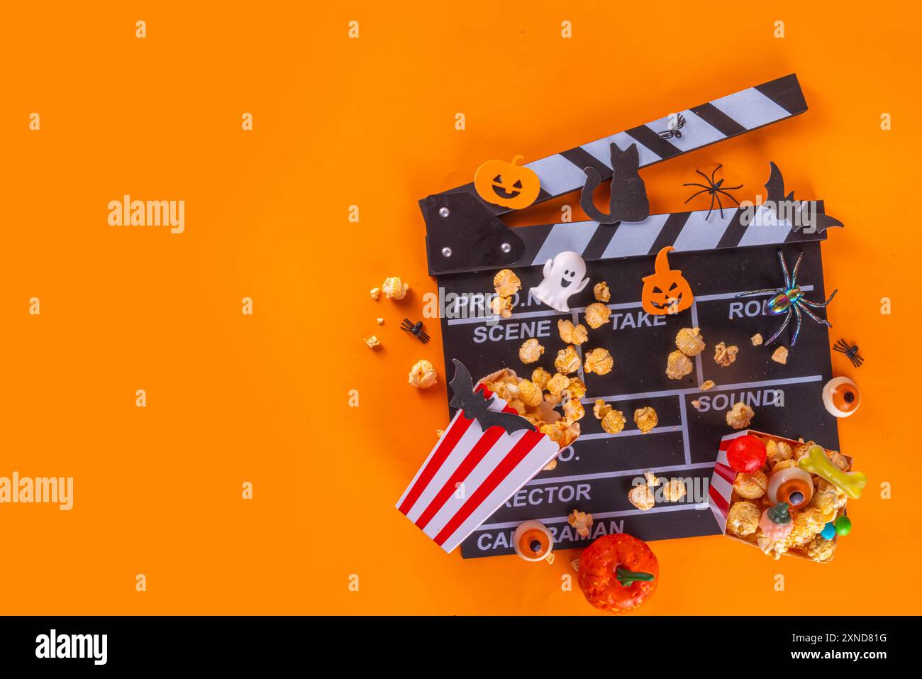 Horrorfilm, Filmabend, Halloween-Kinoparty mit Süßwareneimer, Popcorn, Filmklapperbrett und Halloween-Dekorationen Stockfoto