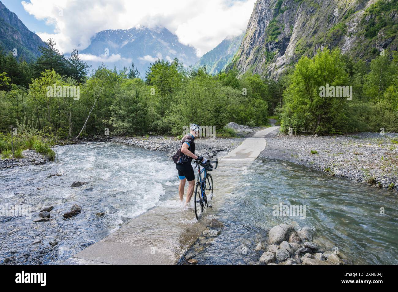 Ein Radfahrer nutzt seine Chancen mit einem Kaltwasserfluss, anstatt die Hauptstraße Romanche Valley bei Bourg d'Oisans in den französischen Alpen zu riskieren Stockfoto