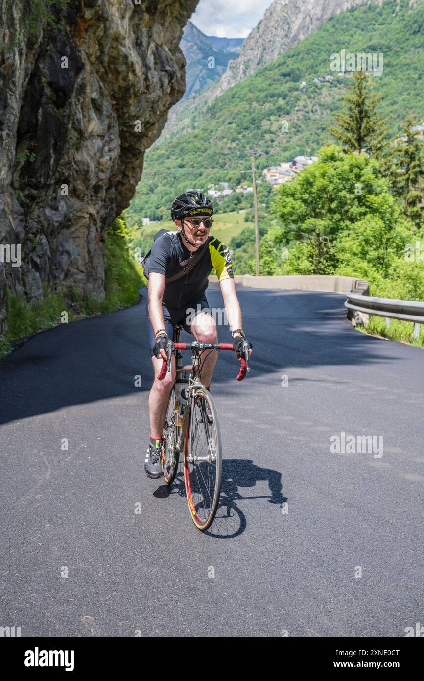 Männlicher Radfahrer, der die Balkonstraße D530 nach Saint-Christophe-en-Oisans, Ecrins-Nationalpark, Französische Alpen besteigt. Stockfoto