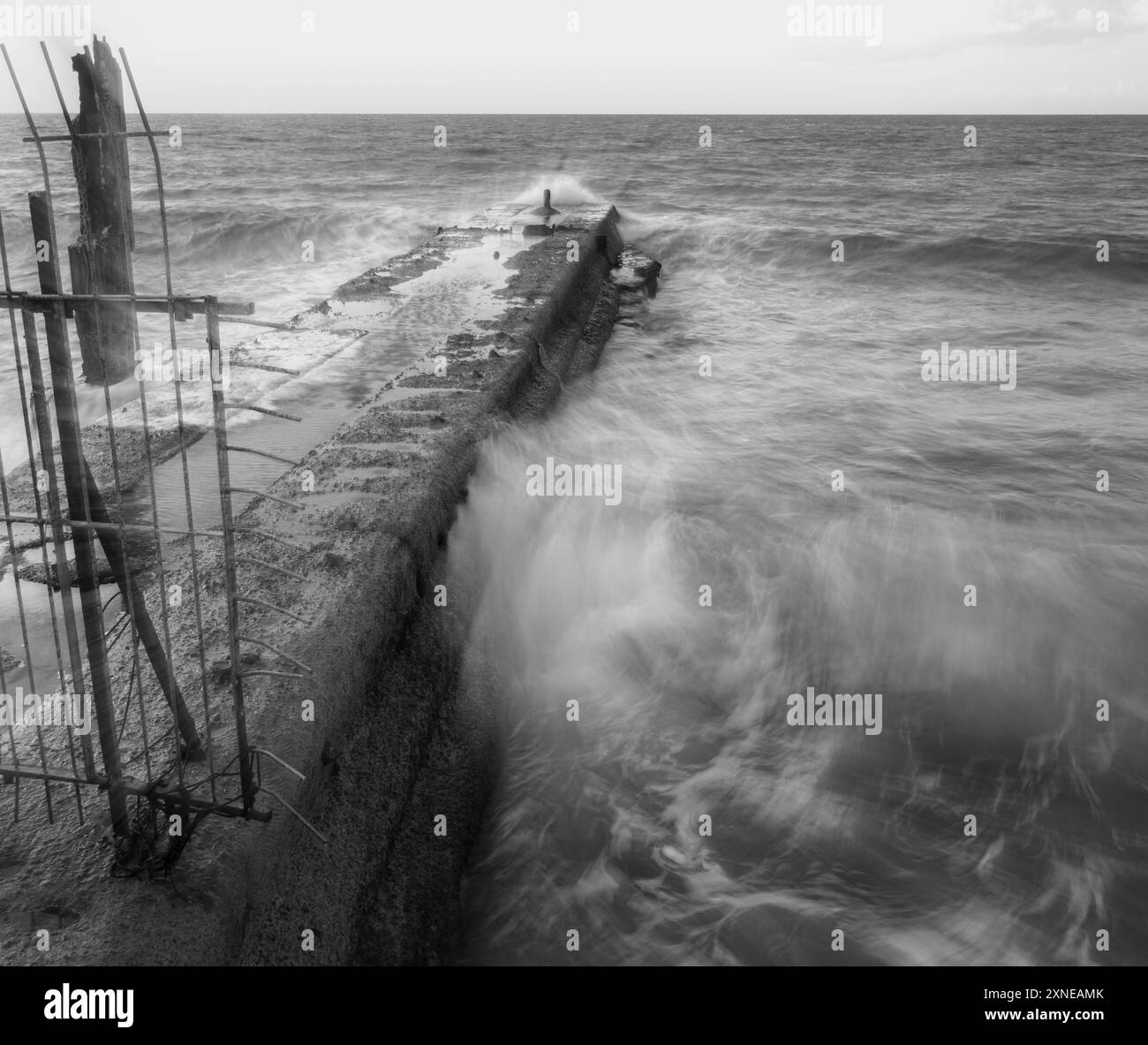 Langsame Bewegung von Wellen, die auf einen Wellenbrecher treffen Stockfoto
